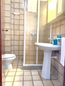 y baño con aseo, lavabo y ducha. en Marina Bay View Apartment, en Bevazzana