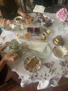 deux personnes assises à une table avec des tasses et des assiettes de nourriture dans l'établissement Bed and Breakfast à Rochefort-en-Terre, à Rochefort-en-Terre