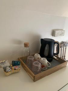 taca z dzbankiem do kawy i innymi przedmiotami na ladzie w obiekcie Bed and Breakfast à Rochefort-en-Terre w mieście Rochefort-en-Terre