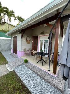 a house with a patio with a table and chairs at Bakoua Bungalow - Jacuzzi in Gros-Morne