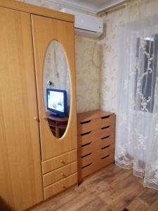 Habitación con espejo y tocador con TV. en Apartment 28,Myru Avenue, en Izmaíl