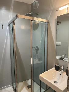 a bathroom with a glass shower and a sink at Venetian Apartments in Venice