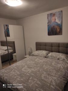 a bedroom with a bed and a painting on the wall at Apartman David in Senj