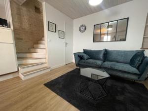 sala de estar con sofá azul y escaleras en L'escale - Centre ville - proche gare SNCF - Wifi, en Niort