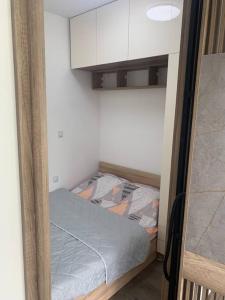 ein kleines Schlafzimmer mit einem kleinen Bett in einem Zimmer in der Unterkunft Cozy apartment in Skopje at perfect location in Skopje