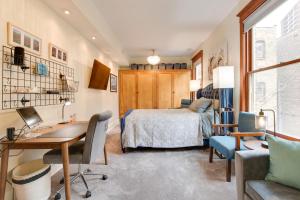 een slaapkamer met een bed, een bureau en een stoel bij Chic Chicago Apartment about 1 Mi to Wrigley Field! in Chicago