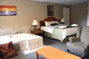a hotel room with a bed and a bath tub at Colonial Resort-1000Islands in Gananoque