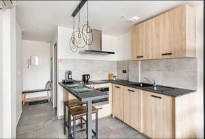 a kitchen with wooden cabinets and a black counter top at Saint-Étienne Bellevue Confort 3 in Saint-Étienne