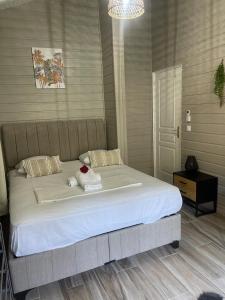 a bedroom with a large bed with a flower on it at Palmier bungalow- piscine in Gros-Morne