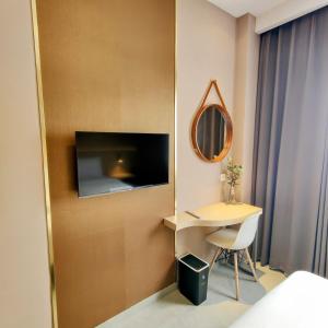 a hotel room with a desk and a mirror at The Mango Suites by Flat06 in Jakarta