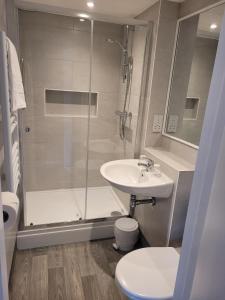 ein Bad mit einer Dusche, einem Waschbecken und einem WC in der Unterkunft Cavendish Hotel in Exmouth