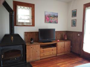 een woonkamer met een tv en een open haard bij Apartamento con terraza y vistas panorámicas en Taüll in Taull