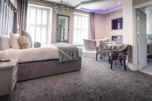 a large bedroom with a large bed and a desk at Wolfscastle Country Hotel in Treffgarne