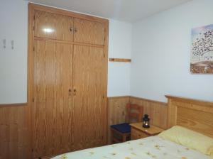 1 dormitorio con armario de madera y cama en Apartamento con terraza y vistas panorámicas en Taüll, en Taüll