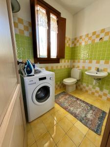 a bathroom with a washing machine and a toilet at Country house lu sambignu in San Pasquale