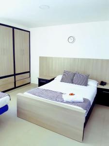 um quarto com uma grande cama branca com toalhas em Hermoso Apartamento Frente a la playa piso 17 Conquistador, el Laguito em Cartagena das Índias