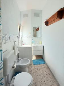 a white bathroom with a toilet and a sink at Zisas in Palermo