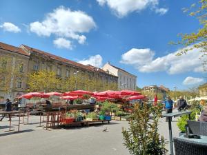 a group of tables with red umbrellas in a city at Apartment Calliope in Zagreb