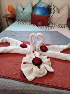 twee zwanen handdoeken op een bed met rozen bij Gîte Morne Vent in Bois Neuf