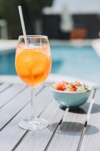 een drankje in een glas naast een kom salade bij Hôtel La Villa Cannes in Cannes