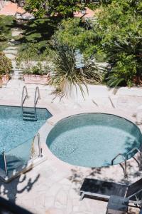 einen Pool mit zwei Stühlen im Hof in der Unterkunft Hôtel La Villa Cannes in Cannes