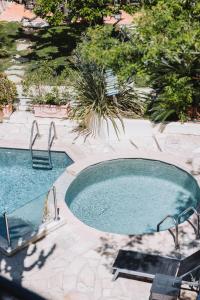 - une piscine avec deux chaises dans la cour dans l'établissement Hôtel La Villa Cannes, à Cannes