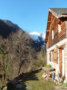 a house with a picnic table next to a mountain at gite le Clot in Seix