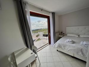 a bedroom with a bed and a balcony with a view at Cape House in Albano Laziale