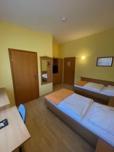 sypialnia z 2 łóżkami, biurkiem i stołem w obiekcie Hotel Highway - Bed & Breakfast w mieście Lieboch