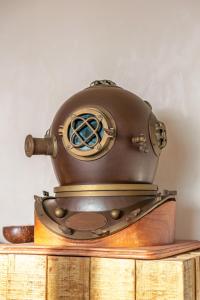 an old steampunk helmet sitting on top of a wooden table at L'Odyssée provençale, un duplex de charme de 2 chambres au pied du village médiéval de Bormes-les-Mimosas, offrant des prestations haut de gamme et une superbe vue sur le Massif des Maures in Bormes-les-Mimosas