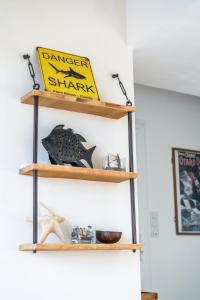 a shelf with a danger shark sign on it at L'Odyssée provençale, un duplex de charme de 2 chambres au pied du village médiéval de Bormes-les-Mimosas, offrant des prestations haut de gamme et une superbe vue sur le Massif des Maures in Bormes-les-Mimosas