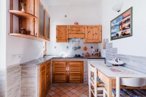 a kitchen with wooden cabinets and a counter top at Lauricella Bed and Breakfast in Lipari +49 photos