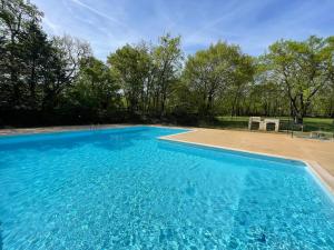 une grande piscine bleue dans une cour dans l'établissement Lodges du Bois Dodo - ancien Camping de Bois Redon, à Septfonds