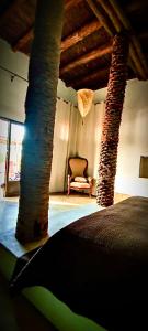 Habitación con árbol, cama y silla en La Parenthese de Marrakech en Tameslouht