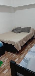 uma cama grande num quarto com piso em madeira em Quarto Suite na Gavea no Rio de Janeiro