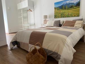 a bedroom with a large bed with a painting on the wall at L'edera Grande in Civezzano
