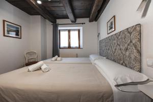 a bedroom with two beds with white sheets at Hostal Etxeberri in Eugi