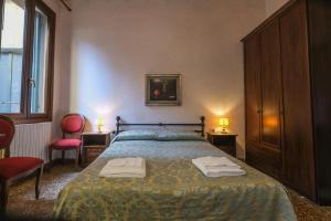 una camera da letto con un letto e due asciugamani di CA'SALVADOR a Venezia