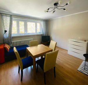 a living room with a dining room table and chairs at Apartament w Zdroju in Duszniki Zdrój