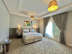 ein Hotelzimmer mit einem Bett und einem Fenster in der Unterkunft Loren Suites Corniche in Dschidda