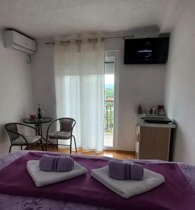 a bedroom with a bed with two pillows on it at Apartman Kristina in Trebinje