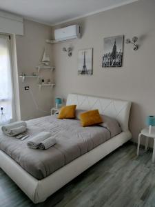 duże łóżko w białym pokoju z żółtymi poduszkami w obiekcie Residence Villa Alba room nr 415 w mieście Gardone Riviera