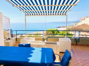 a blue table and chairs on a balcony with the ocean at The Dream - Seafront Loft in Giardini Naxos