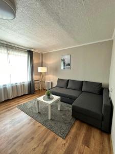 Sea side apartments في يورمالا: غرفة معيشة مع أريكة وطاولة