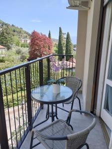 patio con mesa y sillas en el balcón en Residence Villa Alba room nr 415, en Gardone Riviera