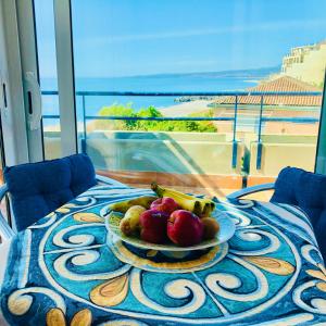 a plate of fruit on a table with a view at The Dream - Seafront Loft in Giardini Naxos