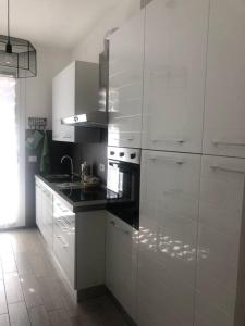 een keuken met witte kasten en een fornuis met oven bij Appartamento Veronica, per lavoro e relax in Corsico