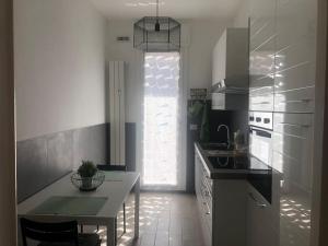 a kitchen with a table and a large window at Appartamento Veronica, per lavoro e relax in Corsico