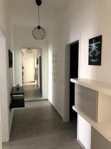 コルシコにあるAppartamento Veronica, per lavoro e relaxの白い壁の廊下、ペンダントライト付きの廊下が備わる客室です。