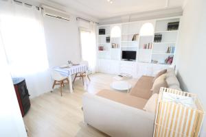 - un salon blanc avec un canapé et une table dans l'établissement Apartamento Boutique, à Cenes de la Vega